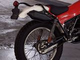 a red and white motorcycle parked in a parking garage