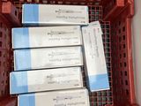 several boxes of toothpaste in a plastic container on a table