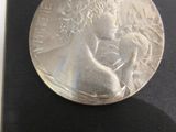 a silver coin sitting on top of a black case
