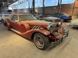 a rusted car parked in a garage with other cars in the background