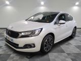 une voiture blanche est garée dans une pièce au sol à carreaux