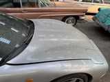 several old cars are parked in a parking lot near a building