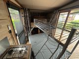 a bunk bed in the middle of a room with a stove