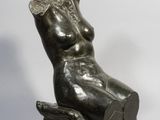 une photo d'une sculpture représentant une femme assise sur une chaise