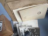 a pile of old photos on the floor next to a dresser