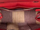 a close up of a red purse with a checkered lining