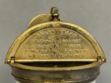 an old brass plate with writing on it sitting on a table