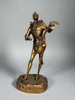 statue en bronze représentant un homme avec une guitare, posée sur un socle
