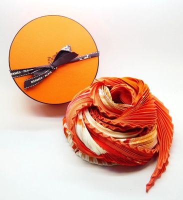 a ball of yarn next to a box of scissors