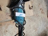 a blue and black drill on the floor next to a wall