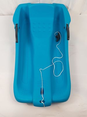 the blue sled is sitting on the bed with a cord attached to it