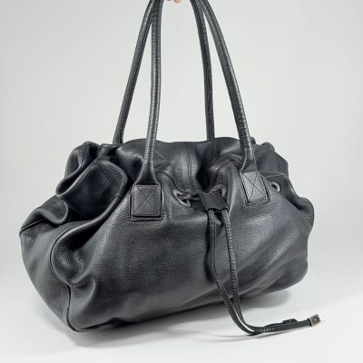 le grand sac noir est tenu par une main
