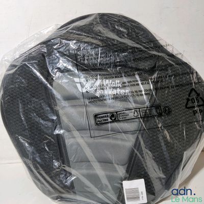 a black object wrapped in plastic on a white surface