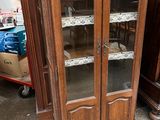 un meuble en bois avec des portes en verre dans une pièce