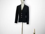mannequin with black jacket and black hat on a gold stand