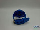 a close up of a blue watch on a white surface