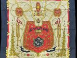un carré brodé de rouge et d'or, orné d'une couronne
