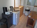 a small kitchen with a refrigerator, microwave, and a coffee maker