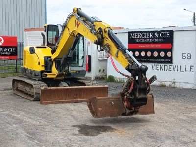 une pelleteuse jaune qui est à l'arrêt dans la terre