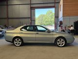 a silver car parked in a garage with other cars in the background