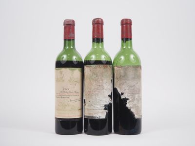 trois bouteilles de vin posées les unes à côté des autres sur une surface blanche