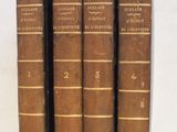 trois vieux livres sont alignés sur une surface blanche