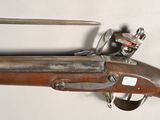 an old rifle with a wooden barrel and a metal handle
