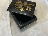 a black box with a gold design on it on a bed