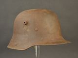 an old helmet on a stand on a gray background