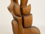 wooden sculpture of a hand holding a bird on a white surface
