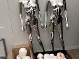 two mannequins that are standing next to a box of doughnuts