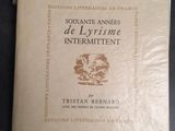 un vieux livre posé sur une table à côté d'une feuille de papier