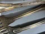 a lot of silver spoons and forks on the table