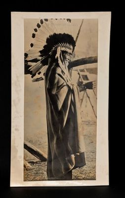 an old black and white photo of a native american man in a feather headdress