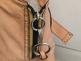 beige leather purse with a zipper on the inside and a zipper on the outside