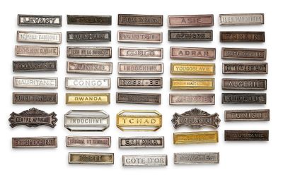 many different types of metal nameplates on a white surface