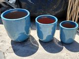 three blue pots sitting next to each other on the ground
