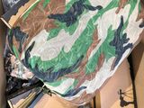 une boîte en carton contenant divers objets, dont un sac de camouflage