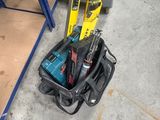 a tool bag with tools on the floor next to a pair of shoes