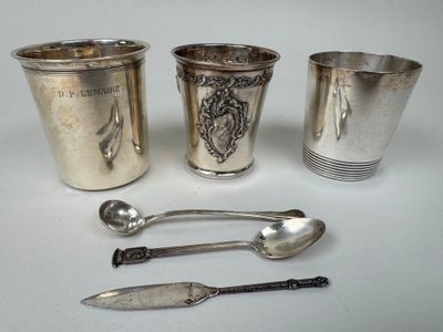 quatre tasses et cuillères en argent posées sur une table
