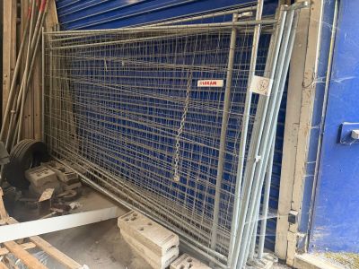 une cage métallique sur laquelle est accrochée une pancarte, devant un mur bleu