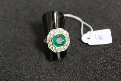 un gros plan d'une bague ornée d'une pierre verte sur un fond noir