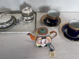 un plateau avec une théière, un plateau avec une théière, un plateau avec une théière et un plateau avec une tasse et une soucoupe