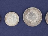 four silver coins are arranged in a row on a blue surface