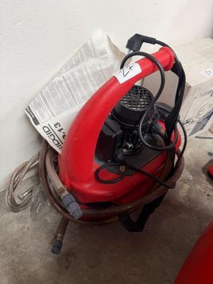 un ventilateur rouge posé sur une table, à côté d'une chaise rouge