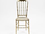 a gold chair with a white seat on a white background