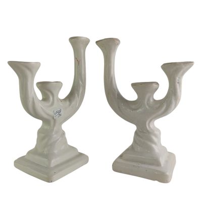 pair of white ceramic candlesticks with a bird design on each of them