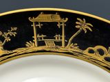 une assiette ornée d'un motif noir et or