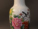 a white vase with flowers and birds painted on it