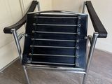 black leather and chrome folding chair in a corner of a room